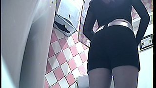 Hot brunette young chick in black panties pisses in the toilet